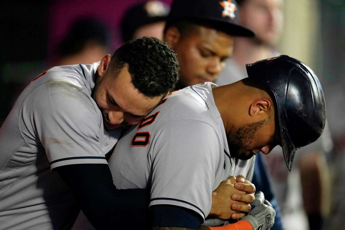 Houston Astros' Yuli Gurriel, right, gets a hug from Yordan Alvarez after  hitting a two-run home run during the third inning of a baseball game  against the Los Angeles Angels in Anaheim