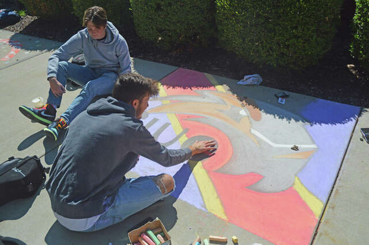 Students from Sigma Phi Epsilon Fraternity at SIUE work on their mural during Wednesday’s Chalk Mural Contest at Stratton Quad. The event is part of SIUE’s Homecoming week.