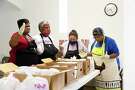 Sarah Smith, from left, Ronda Anderson, Henrietta Palacios and Agnes Scott Taylor give thanks as they prepare meals for the hungry and the homeless.