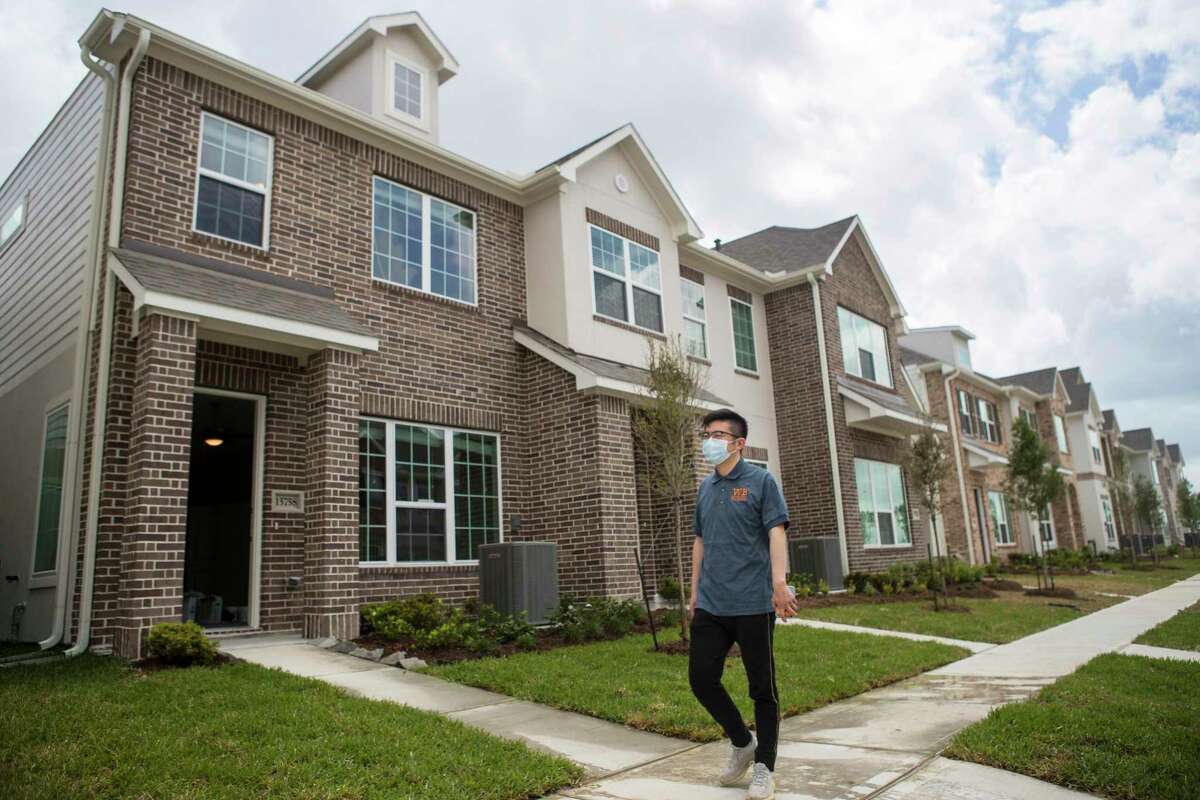 CEO of Wan Bridge Ting Qiao walks past a row of single family townhomes that are completed and ready to lease in the Clearwater at Balmoral subdivision Tuesday, April 6, 2021 in Atascocita. Single-family rentals are drawing increased interest from investors making the bet that people want to live in single-family houses but either will not be able to afford to buy or want to maintain their amenity-rich turnkey lifestyle.