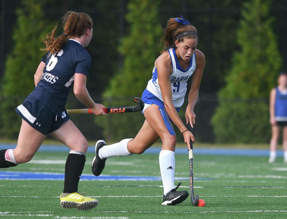 Darien's Raina Johns (9) brings the ball through the midfield while Staples' Isabelle Nahon (6) closes in during a field hockey game in Darien on Wednesday, Sept. 22, 2021.
