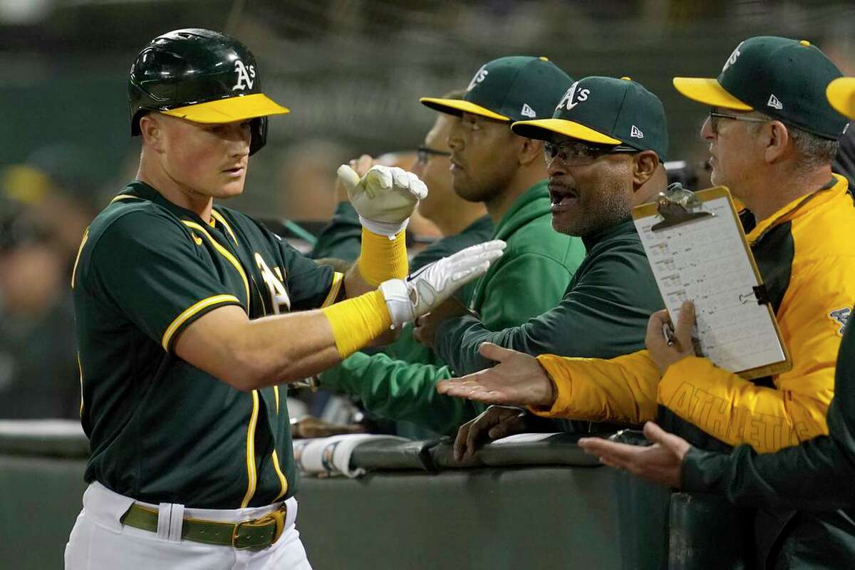 Oakland Athletics' Matt Chapman, left, is congratulated after hitting a home run against the Seattle Mariners during the fifth inning of a baseball game in Oakland, Calif., Wednesday, Sept. 22, 2021. (AP Photo/Jeff Chiu)