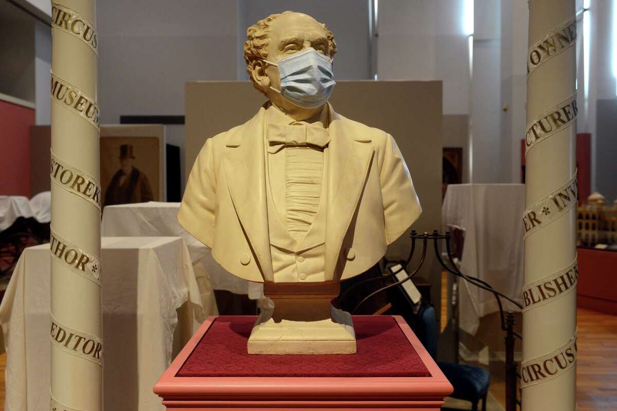 The masked bust of P.T. Barnum stands in a temporary location in the Barnum Museum, in Bridgeport, Conn. Sept. 22, 2021.