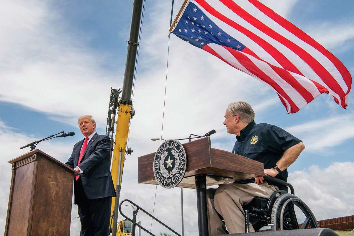 Texas Gov. Greg Abbott, right, listens to former President Donald Trump's address during a tour to an unfinished section of the border wall on Wednesday, June 30, 2021, in Pharr, Texas. (Brandon Bell/Getty Images/TNS)