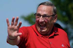 Former Maine Gov. Paul LePage, a Republican gubernatorial candidate, waves while marching in the State of Maine Bicentennial Parade, on Aug. 21 in Lewiston, Maine.