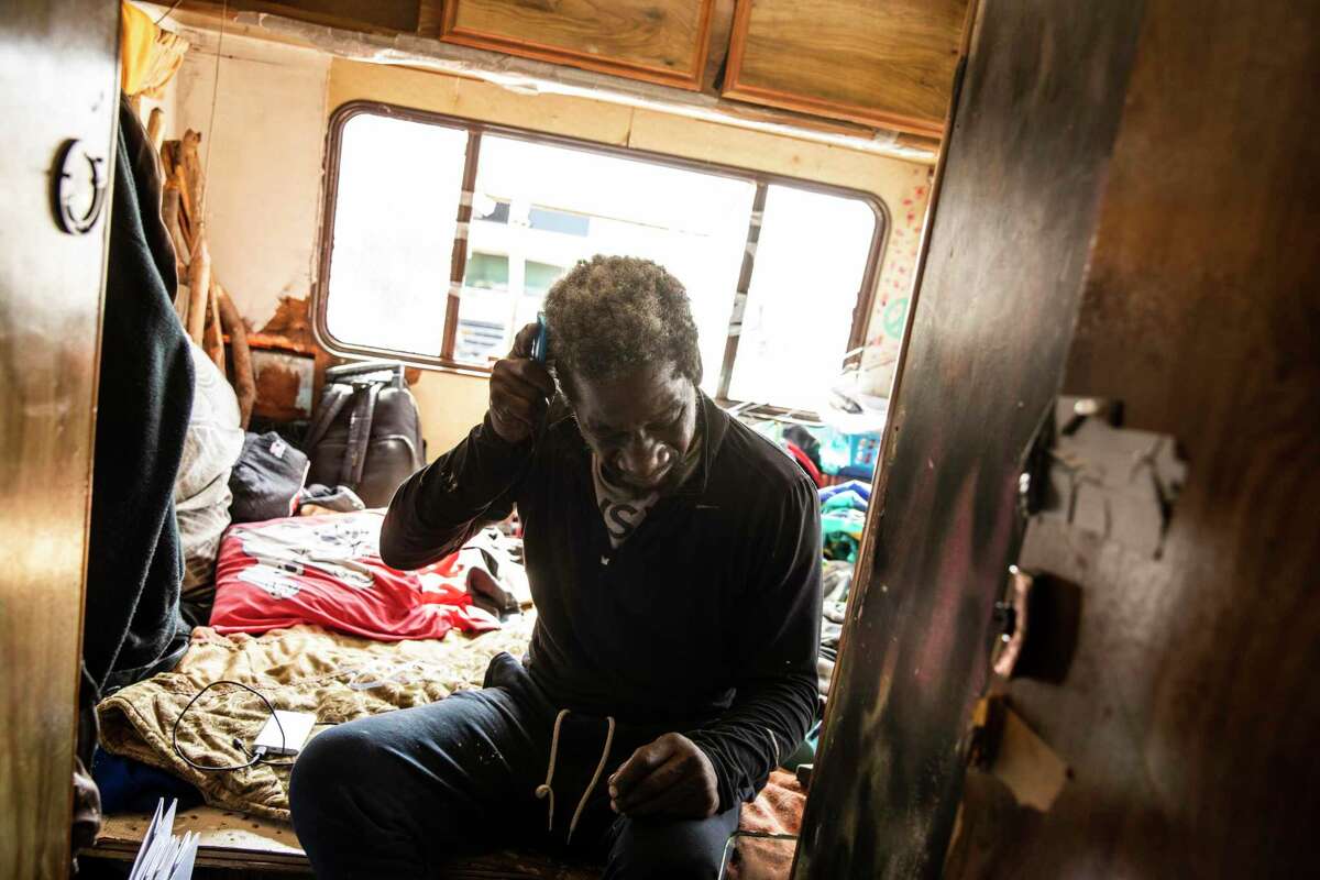 James Keys, 59, brushes his hair after waking up inside his RV parked along Hunters Point Expressway in San Francisco.