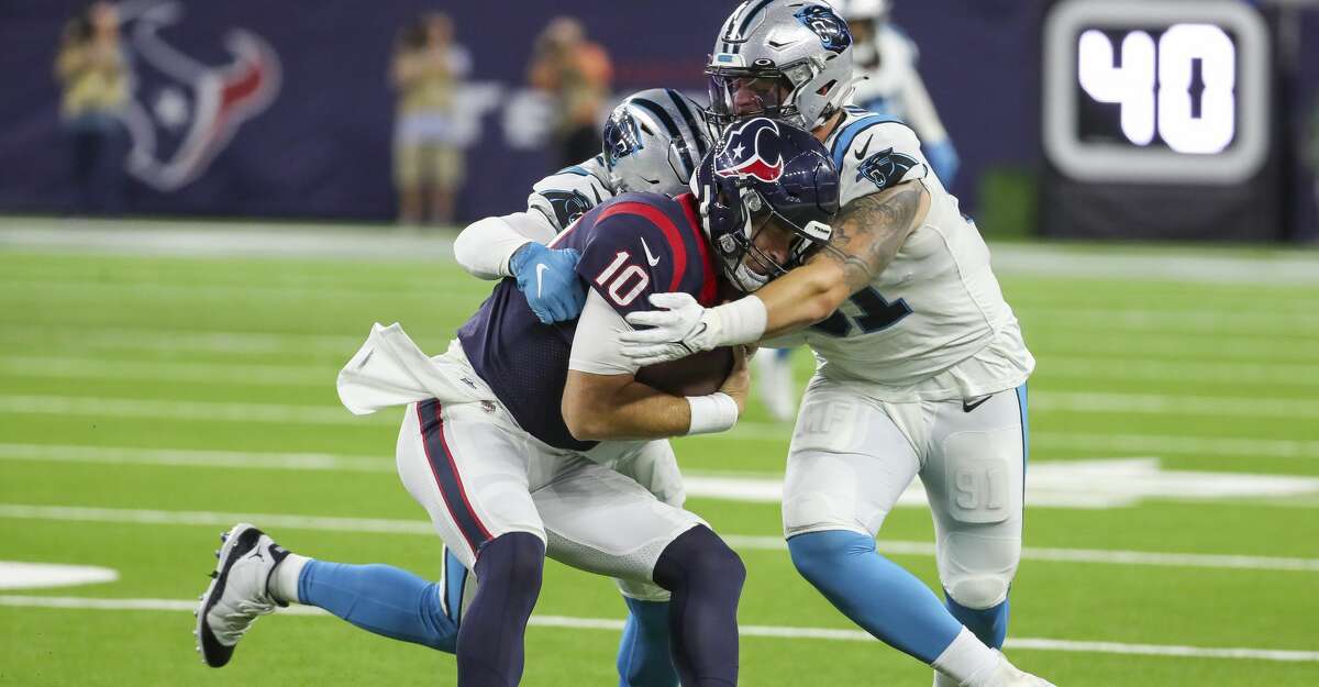 Houston Texans quarterback Davis Mills (10) is sacked by Carolina Panthers linebacker Haason Reddick (43) and defensive end Morgan Fox (91) during the first quarter of an NFL football game Thursday, Sept. 23, 2021, in Houston.