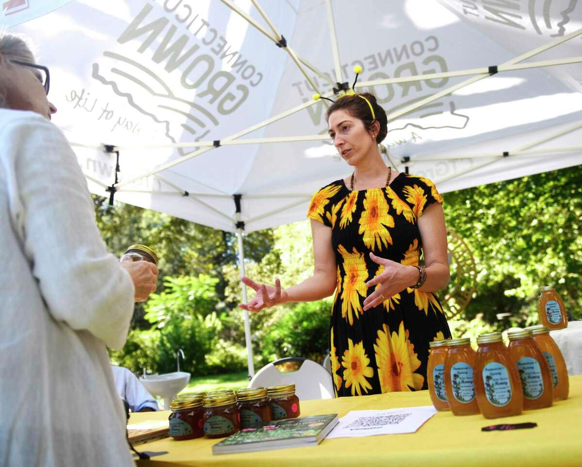 New Canaan's Lia Ferro chats with a customer at her stand, Francesca's Apiary, at the Honey Harvest Festival at Bartlett Arboretum in Stamford, Conn. Sunday, Sept. 19, 2021. The free festival featured an artisan marketplace with more than 20 local vendors, live music, a free yoga and Zumba class, honey and mead tastings, food trucks, children's crafts, and a beekeeping panel discussion.