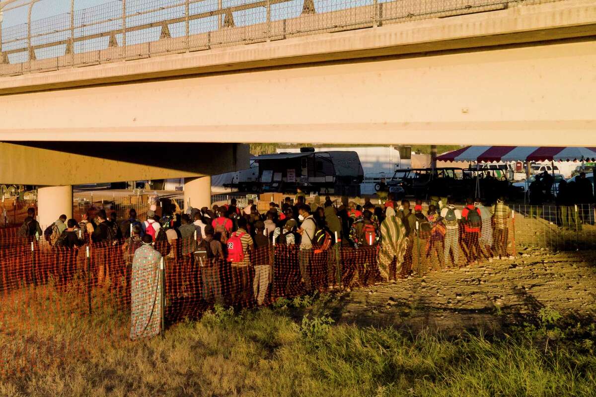 Migrants, many from Haiti, wait in lines to board buses under the Del Rio International Bridge, Friday, Sept. 24, 2021, in Del Rio, Texas.