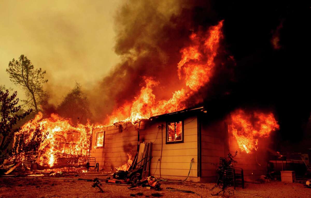 Flames consume a house near Old Oregon Trail as the Fawn Fire burns about 10 miles north of Redding on Thursday.