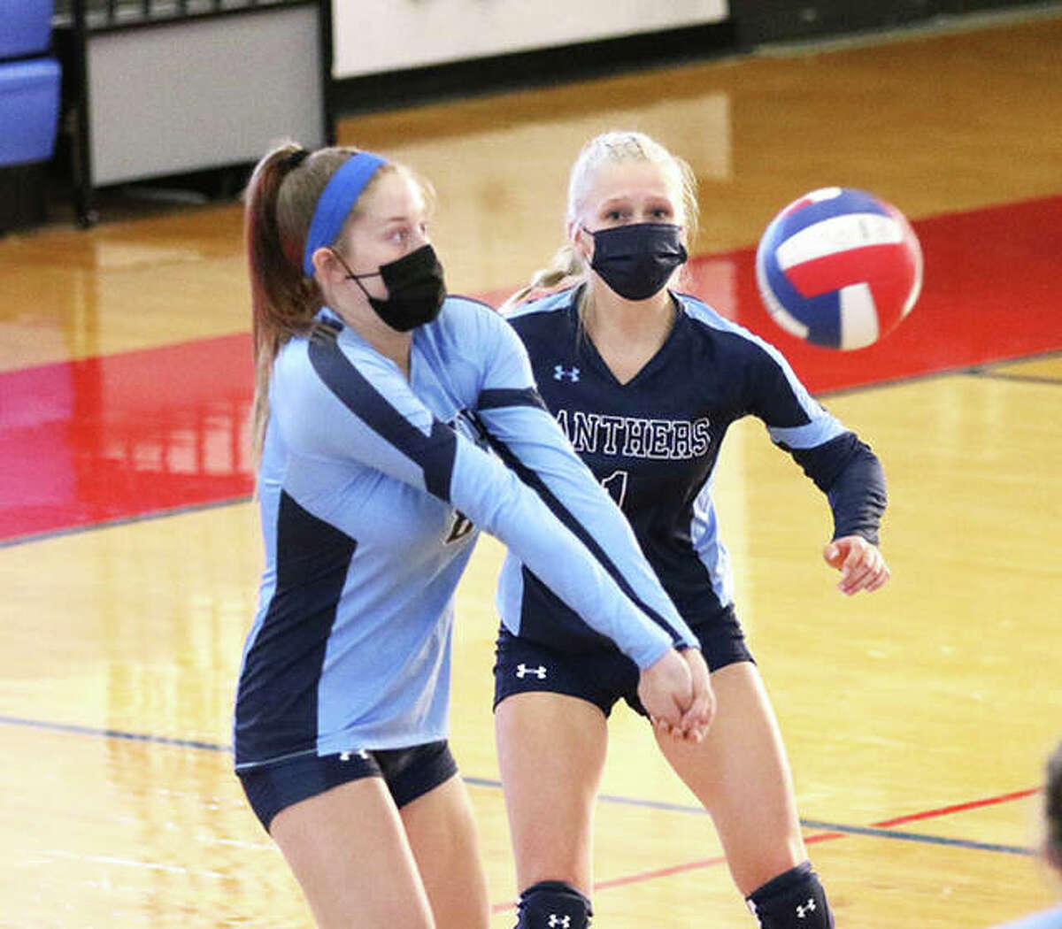 Jersey’s Kendal Davis (left) receives a serve in front of libero Sammie Malley during a match at the Roxana Tourney in August. On Thursday, the Panthers dropped a MVC match to Triad in Jerseyville.