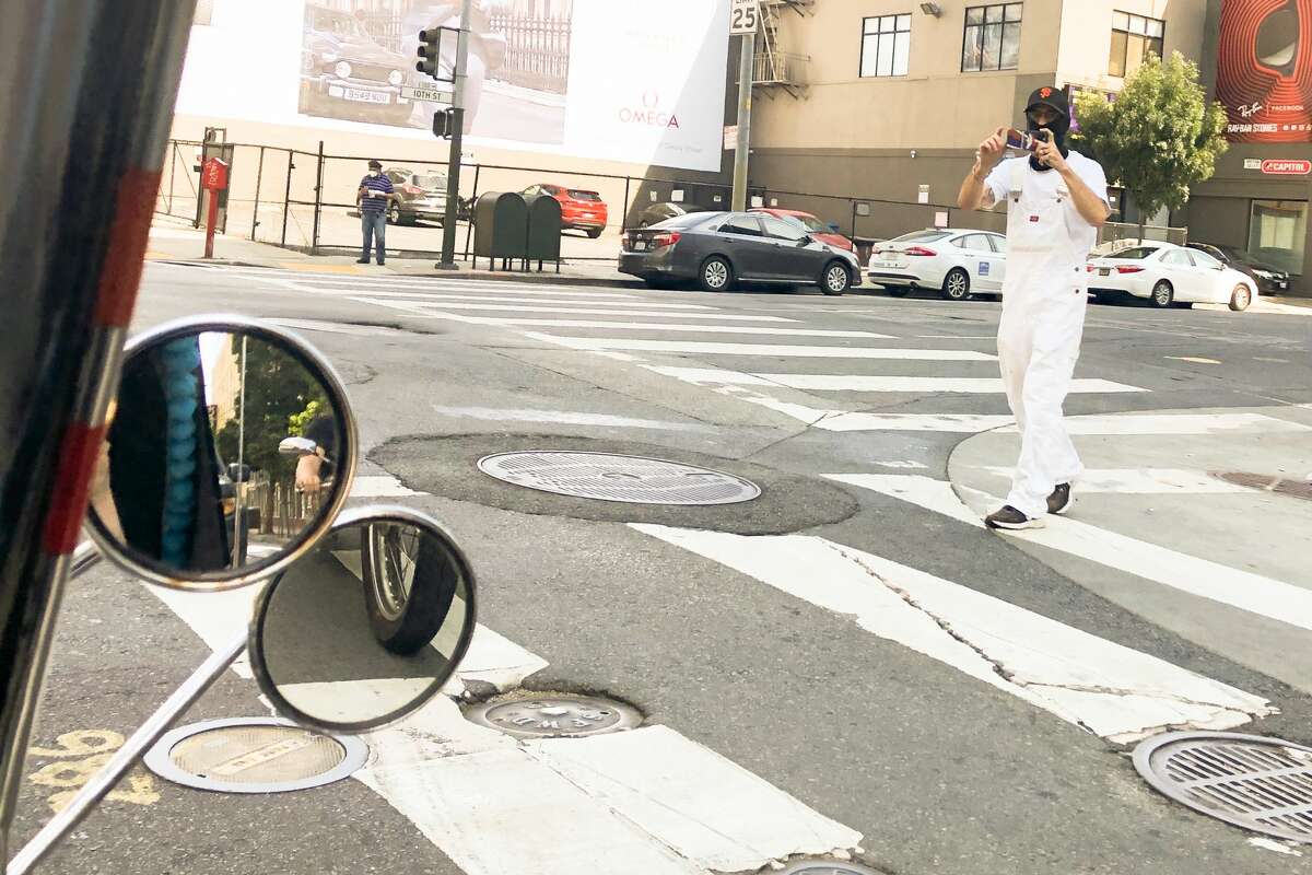 A man stops to take photos of the TNT Traysikel in San Francisco on September 23, 2021.