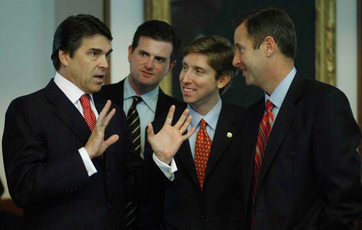 Texas Gov. Rick Perry, left, talks with, from left, Rep. Brandon Creighton, R-Conroe; Rep. Tan Parker, R-Flower Mound; and Rep. Jim Murphy, R-Houston, in the Texas House of Representatives Thursday, March 29, 2007, in Austin, Texas. The three are freshmen in the House.