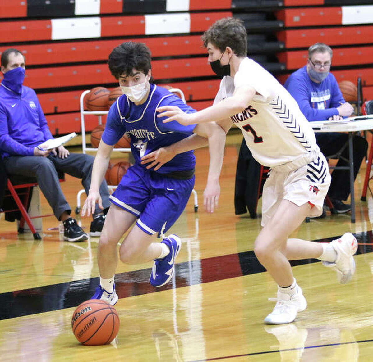 Marquette Catholic’s Owen Williams (left) drives past Triad’s Jake Stewart during a game last season in Troy. Williams is a senior and will lead an Explorers team in its first season as a member of the new Gateway Metro Conference in the 2021-22 season.