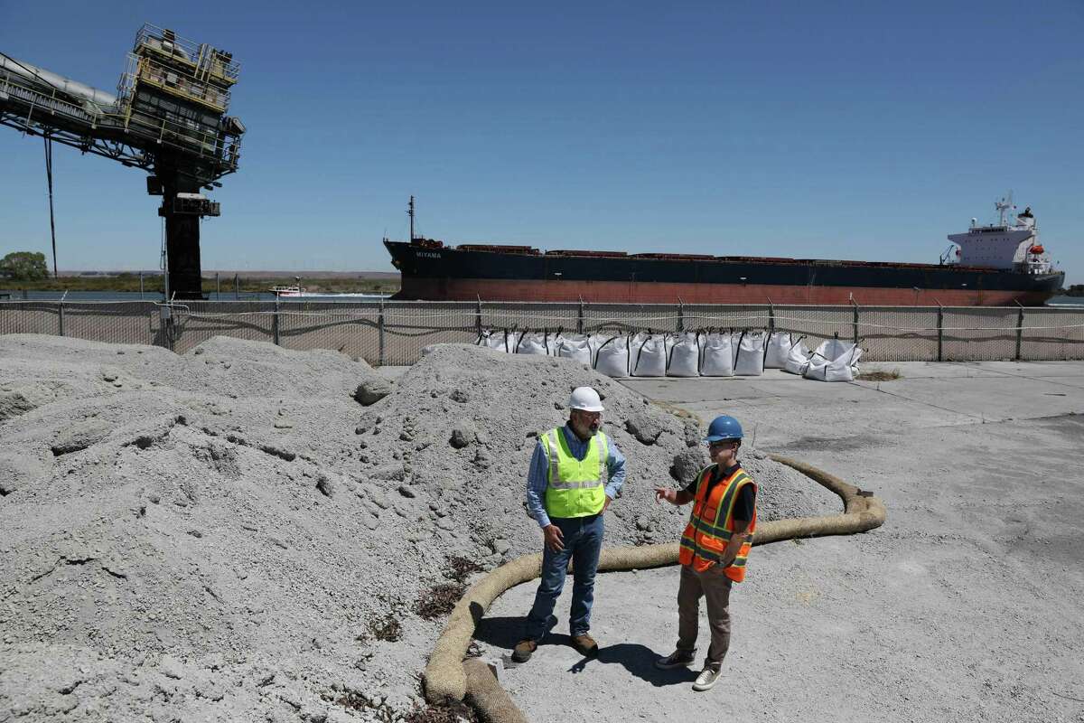 Brent Constantz (left), chief executive officer Blue Planet, and Chris Larsen, co-founder of the Larsen and Lam Climate Initiative, stand next to a pilel of broken down concrete before it is processed as Constantz gives Larsen a tour of SF Bay Aggregates in Pittsburg, a Blue Planet subsidiary.
