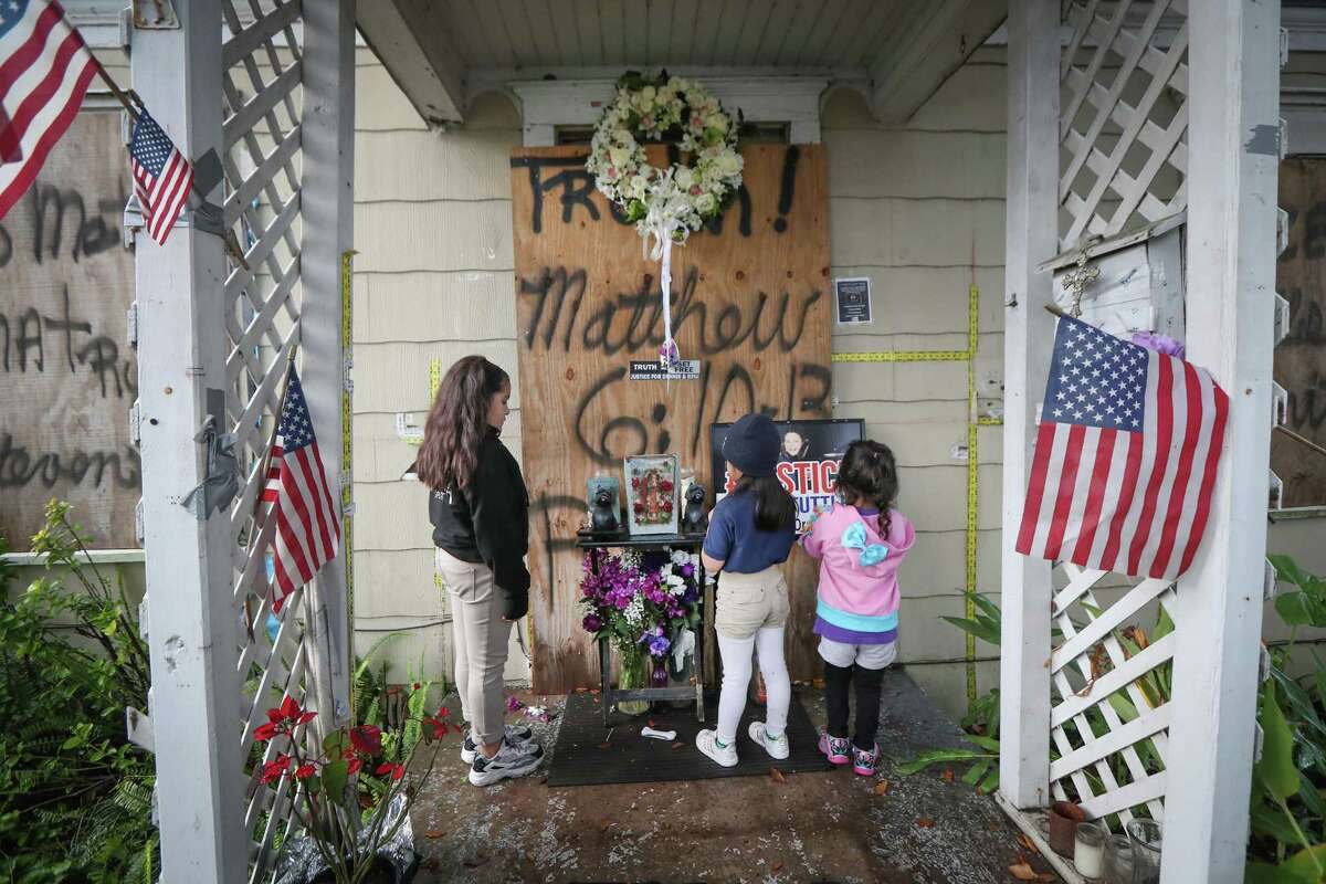 Katelynn, Melody and Emma Becerra pray for shooting victims Rhogena Nicholas and her husband, Dennis Tuttle, after a vigil at 7815 Harding St. on the anniversary of their deaths Tuesday, Jan. 28, 2020, in Houston.