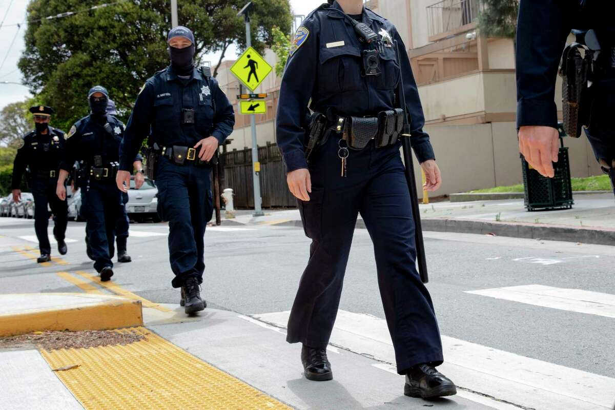 San Francisco police officers wear masks as they monitor the crowd during these June 2020 photos. Nearly 200 employees in the San Francisco Police Department have applied for a religious release from the city's vaccine mandate, by far the largest number of exemptions from any city department.