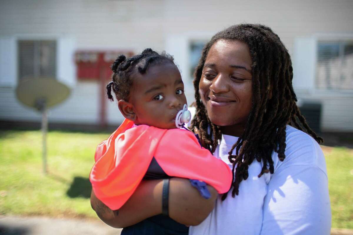 The 910 Apartment Homes resident Jamiesha Brown, 28, holds her baby Bailey Cerf, 1, as she stands for a portrait, Friday, Sept. 24, 2021, in Spring. After several murders in the apartment complex, Brown expressed concern for the safety of her family.