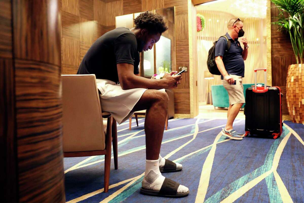 Golden State Warriors' Jonathan Kuminga looks at his phone while waiting to get an extra key to his room at the Aria Resort and Casino in Las Vegas, Nevada, on Monday, August 9, 2021.