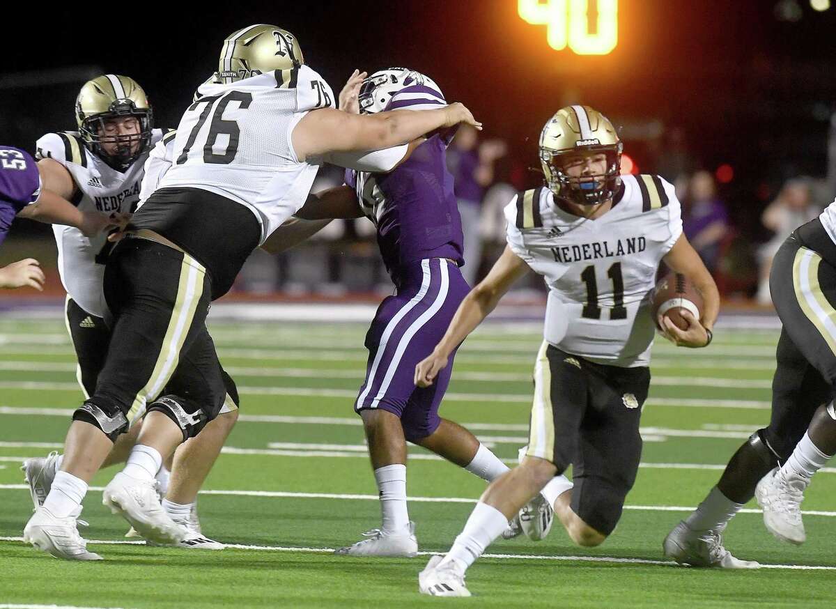 Port Neches-Groves' defense is held off as Nederland's Luke Broussard runs the ball during Friday's Mid-County match-up at PNG. Photo made Friday, September 24, 2021 Kim Brent/The Enterprise