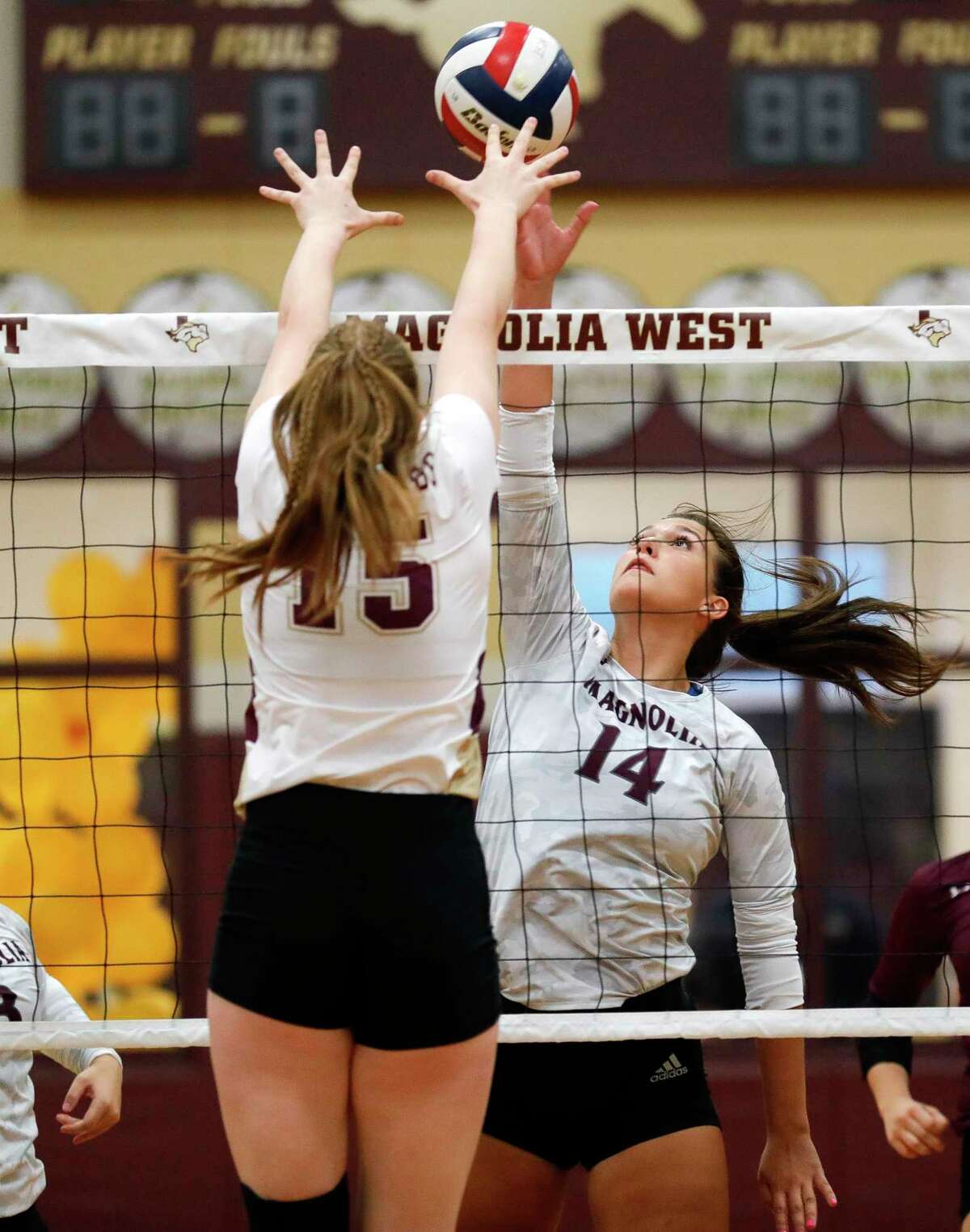 Magnolia’s Alex Bull (14) tips the ball past Magnolia West’s Evan Snook (15) during the third set of a District 19-5A high school volleyball match at Magnolia West High School, Tuesday, Sept. 21, 2021, in Magnolia.
