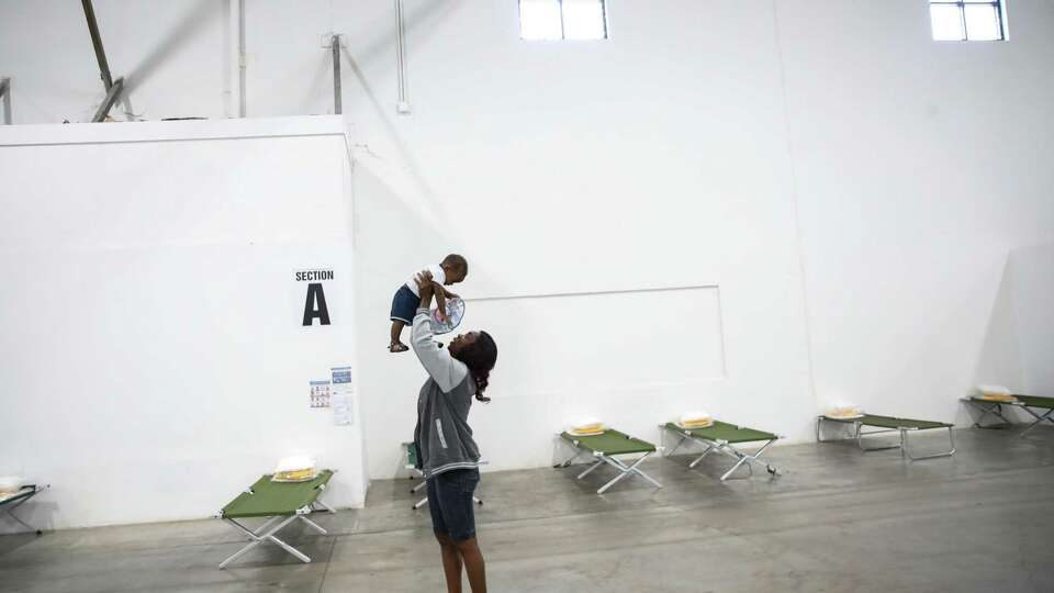 Vallerie Lamour, a Haitian migrant, plays with Jayden Metayer, the child of a woman she met while crossing the Rio Grande near Del Rio, while the mother speaks with a reporter Saturday, June 5, 2021, at a shelter in Houston.