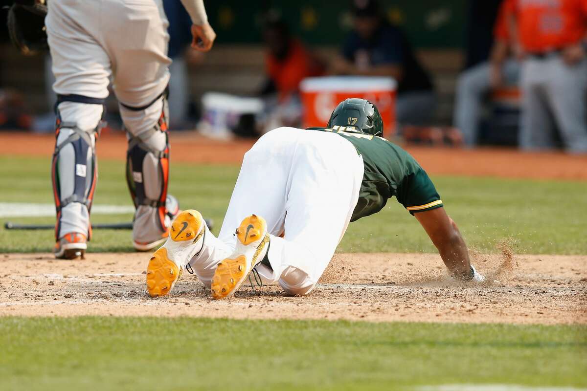 OAKLAND, CALIFORNIA - SEPTEMBER 25: Elvis Andrus #17 of the Oakland Athletics slides into home plate after injuring himself while scoring the winning run on a double by Starling Marte #2 in the bottom of the ninth inning against the Houston Astros at RingCentral Coliseum on September 25, 2021 in Oakland, California. (Photo by Lachlan Cunningham/Getty Images)