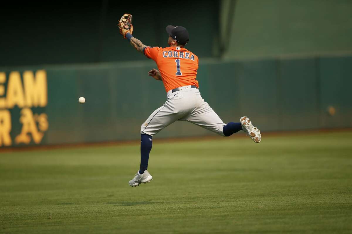 Houston Astros shortstop Carlos Correa (1) misses the catch for an RBI single by Athletics' Josh Harrison (1) in the seventh inning during an MLB game at RingCentral Coliseum on Saturday, Sept. 25, 2021, in Oakland, Calif.