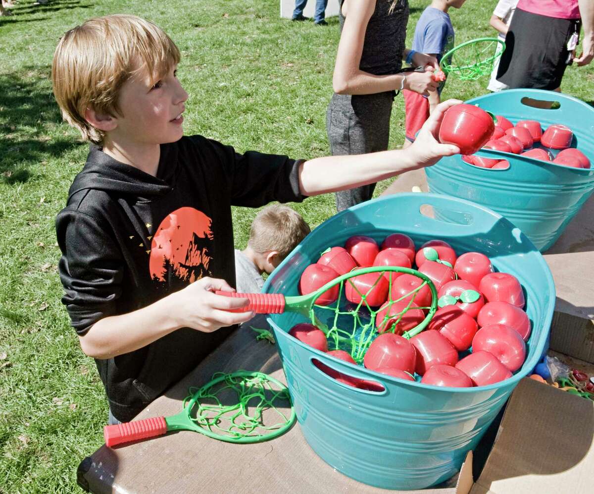 Mason Breidster, 8 of New Milford, looks for a prize at the apple bobbing event during the Apple Festival on the New Milford town green. Saturday, Sept. 25, 2021