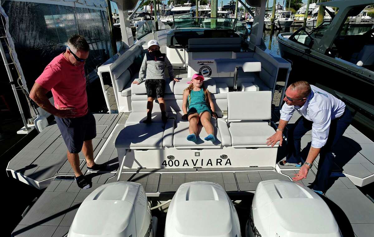 Visitors including Wes Eisenhandler and his children, Jack and Madison, 8 and 10, browse craft like the 400 Aviara at the Norwalk Boat Show Saturday, Sept. 25, 2021 at Cove Marina in Norwalk, Connecticut.