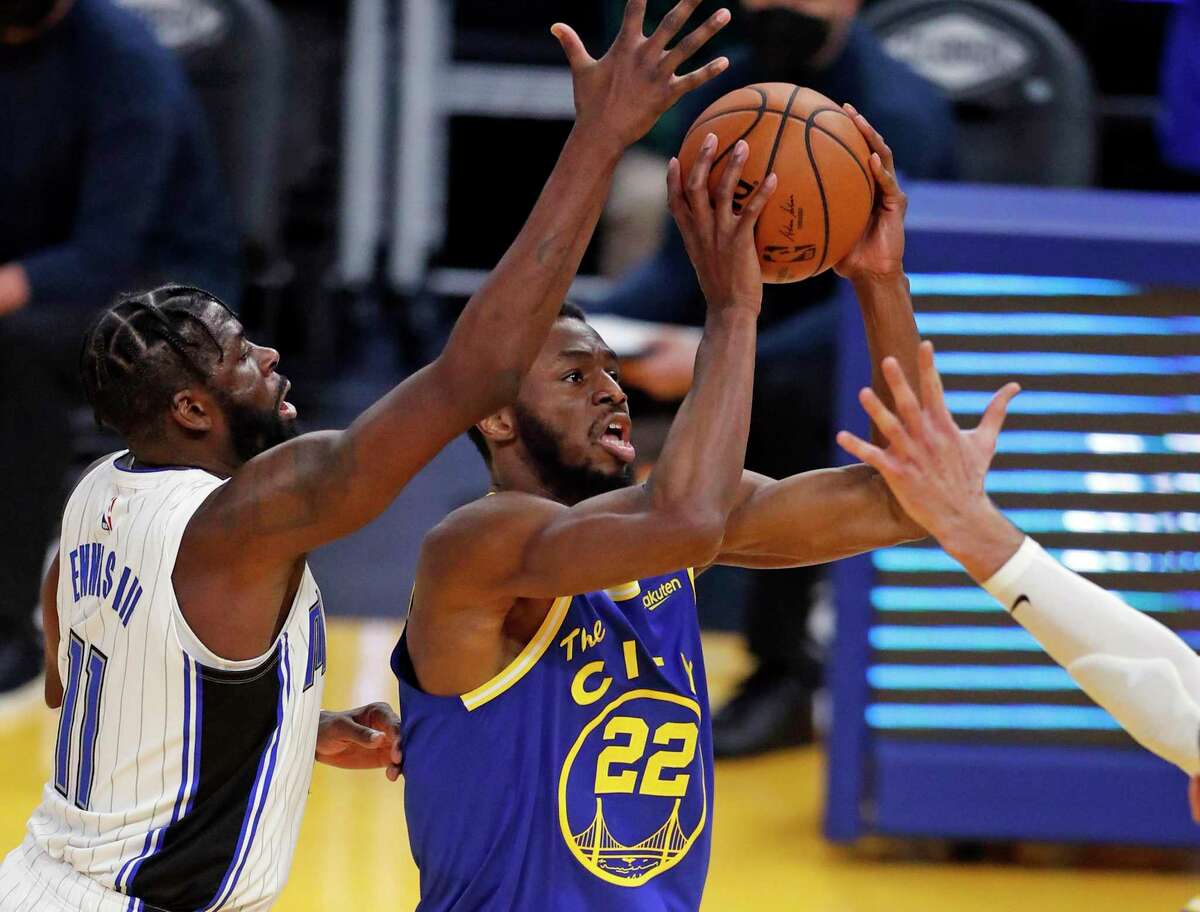 Golden State Warriors' Andrew Wiggins shoots against Orlando Magic's James Ennis in 2nd quarter during NBA game at Chase Center in San Francisco, Calif., on Thursday, February 11, 2021.