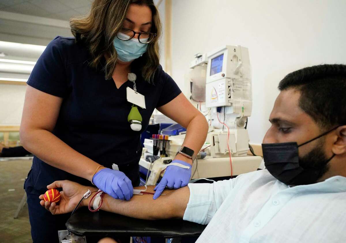 Crystal Duran, a phlebotomist with Gulf Coast Regional Blood Center, left, works with Joyab Prasla of Spring as he gives blood at Ismaili Jamatkhana, 24525 Community Center Dr., Sunday, Sept. 26, 2021 in Spring. Ismaili Muslims across the world are hold their Global Civic Day on Sunday. In the Houston area, Ismailis are holding blood drives.
