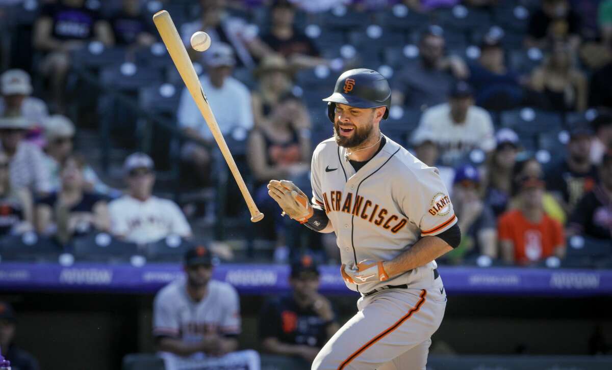 San Francisco Giants' Brandon Belt is hit by a pitch from Colorado Rockies reliever Lucas Gilbreath in the seventh inning of a baseball game in Denver, Sunday, Sept. 26, 2021.