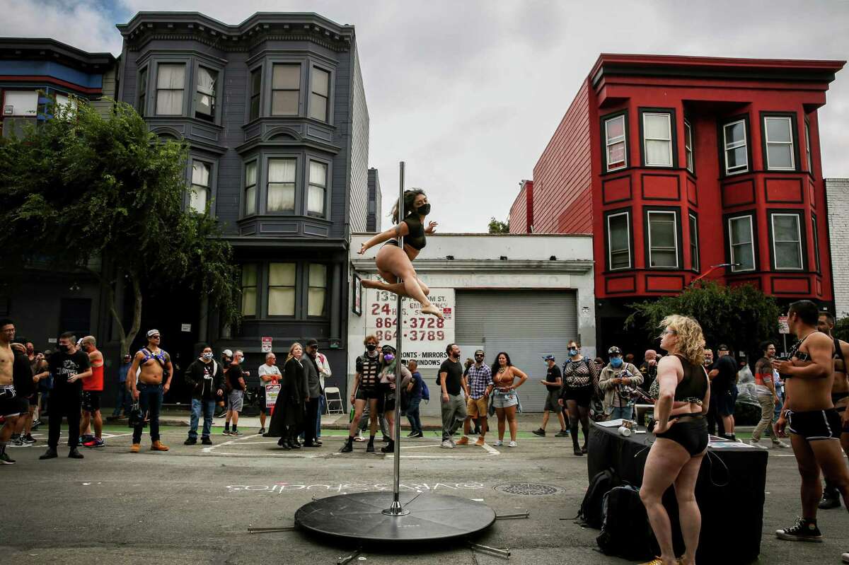 Pole-dancing instructor Nicole Rems performs in front of a crowd during the 2021 Folsom Street Fair in San Francisco. The fair is organized by the same group that puts on the Up Your Alley fair, which takes place this weekend.