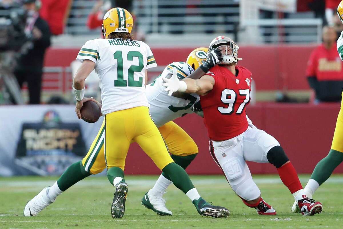San Francisco 49ers' Nick Bosa is held as Green Bay Packers' Aaron Rodgers looks to scramble in 1st quarter during NFL game at Levi's Stadium in Santa Clara, CA on Sunday, September 26, 2021.