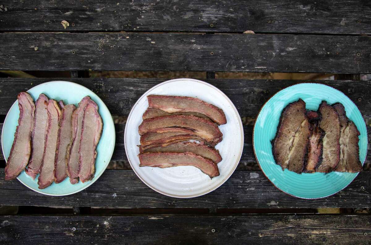 Pre-cooked brisket from H-E-B Smokehouse, left, Pruski’s Market, center, and True Texas BBQ, right, are seen on display at Chuck's Food Shack.