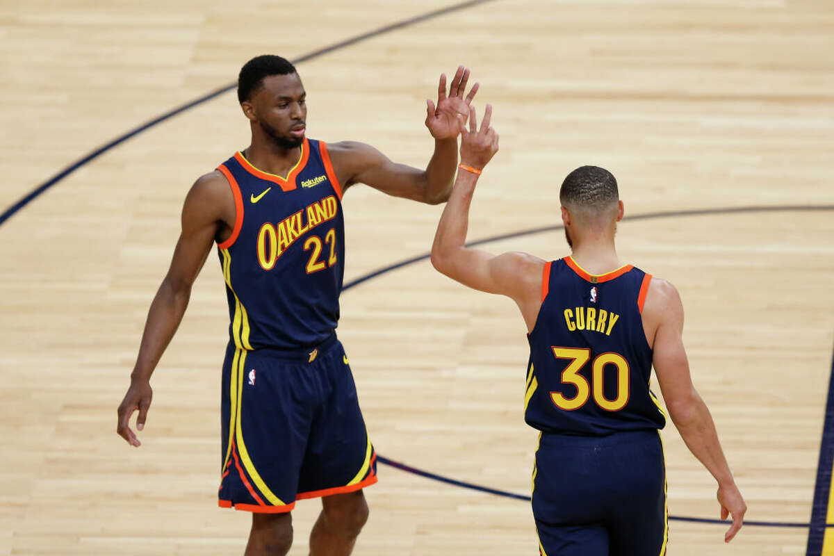 Stephen Curry of the Golden State Warriors celebrates a basket with Andrew Wiggins in the first quarter NBA Play-In Tournament game against the Memphis Grizzlies at Chase Center on May 21, 2021 in San Francisco, California.