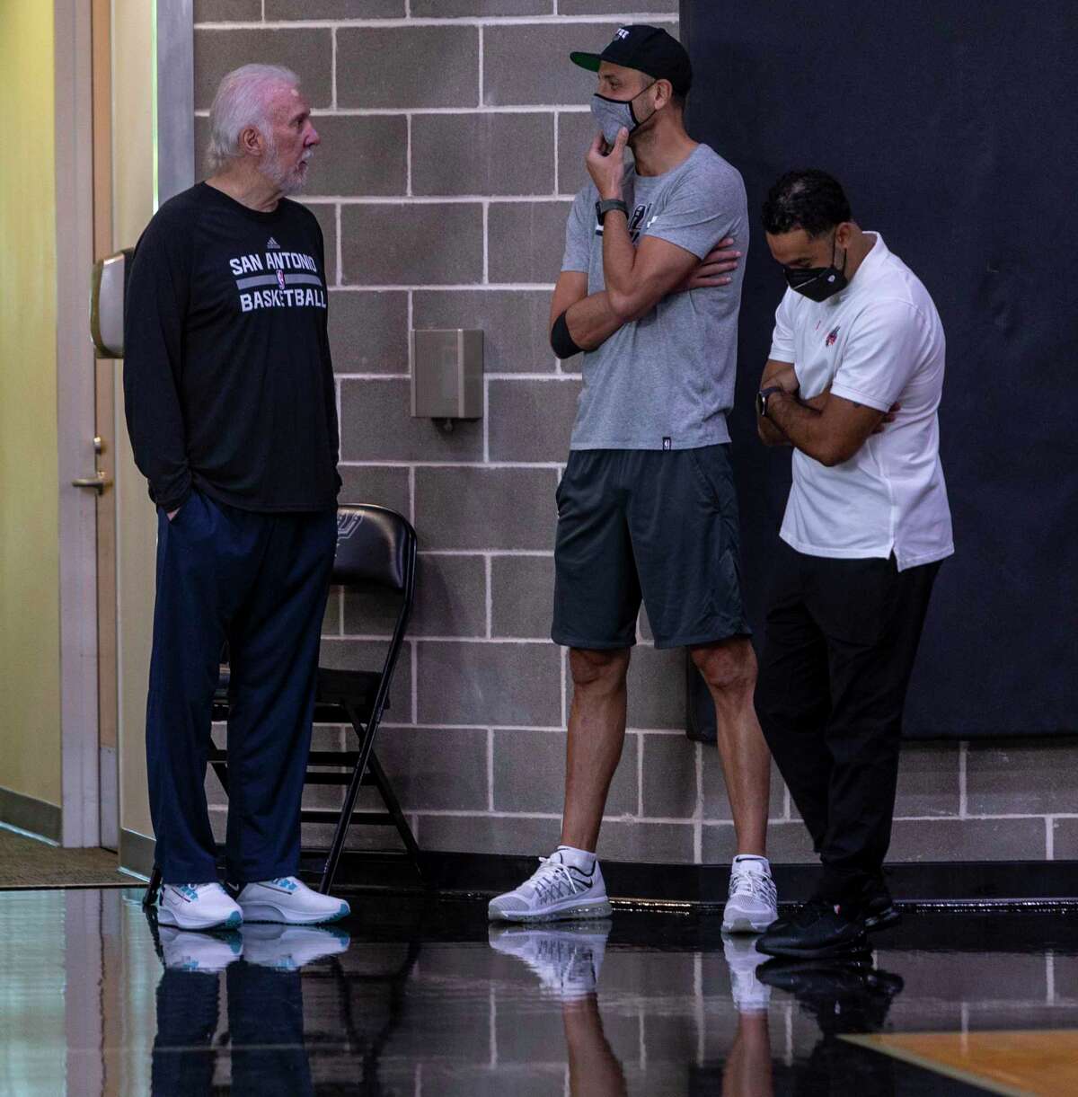 Spurs coach Gregg Popovich, left, talks Monday, Sept. 27, 2021 at the Spurs' practice facility with Manu Ginobili, center, during the team's media day