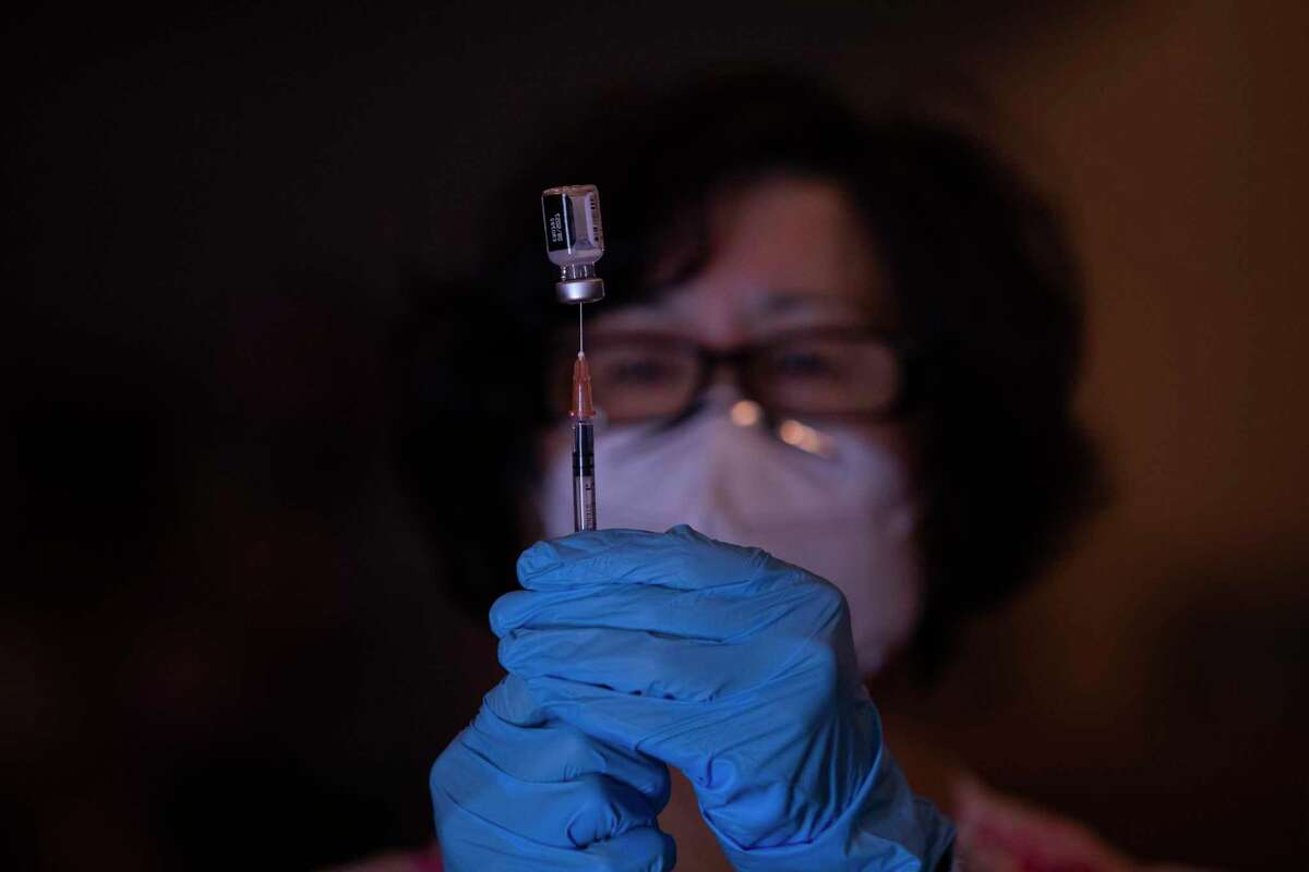 Rosa Cheng, a clinical registered nurse lead with Visit Healthcare, a San Francisco Vaccination Clinic, draws a Pfizer vaccine into a syringe at a new vaccination site at Balboa High School in San Francisco , Calif.