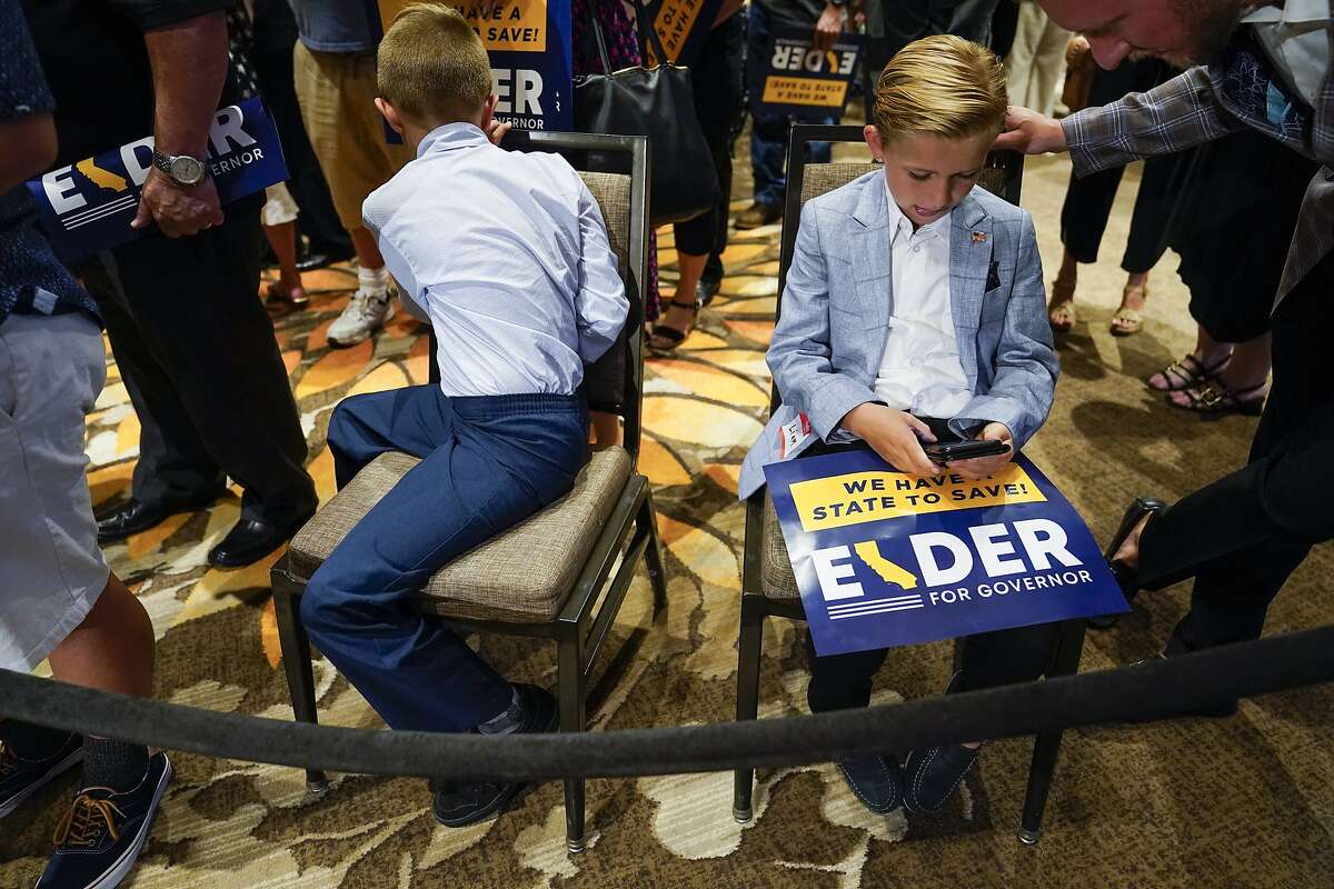 Two boys and other supporters of republican conservative radio show host Larry Elder wait for results after polls close for the California gubernatorial recall election Tuesday, Sept. 14, 2021, in Costa Mesa, Calif. The rare, late-summer election, which challenged California Governor Gavin Newsom, has emerged as a national battlefront on issues from COVID-19 restrictions to climate change. (AP Photo/Ashley Landis)