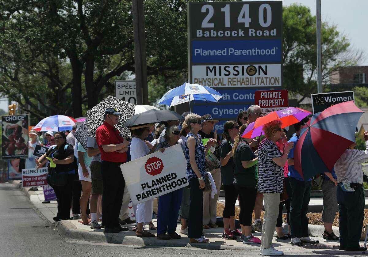 People line up Tuesday July 28, 2015 at 2140 Babcock Road in front of Planned Parenthood during a "Women Betrayed Rally." Protesters at the event were calling on government officials to investigate and defund Planned Parenthood.
