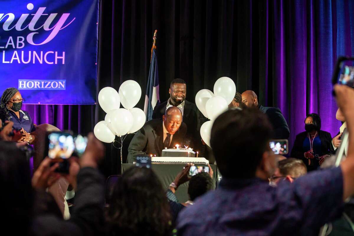 Houston Mayor Sylvester Turner blows out candles on a birthday cake brought out for him as Curtis "50 Cent" Jackson looks on as Jackson's song "In Da Club" plays during the induction ceremony for the G-Unity Business Lab, Monday, Sept. 27, 2021, at Wheatley High School in Houston. The initiative is a partnership between Curtis "50 Cent" Jackson's G-Unity Foundation and Houston Independent School District. The business lab will offer MBA-style business classes for students interested in entrepreneurial endeavors.