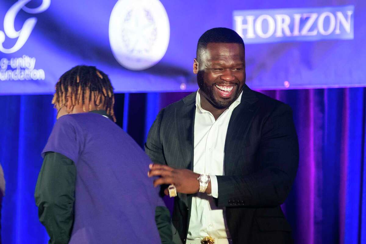 Curtis "50 Cent" Jackson laughs as he greets a student from Wheatley High School during the induction ceremony for the G-Unity Business Lab, Monday, Sept. 27, 2021, at Wheatley High School in Houston. The initiative is a partnership between Curtis "50 Cent" Jackson's G-Unity Foundation and Houston Independent School District. The business lab will offer MBA-style business classes for students interested in entrepreneurial endeavors.