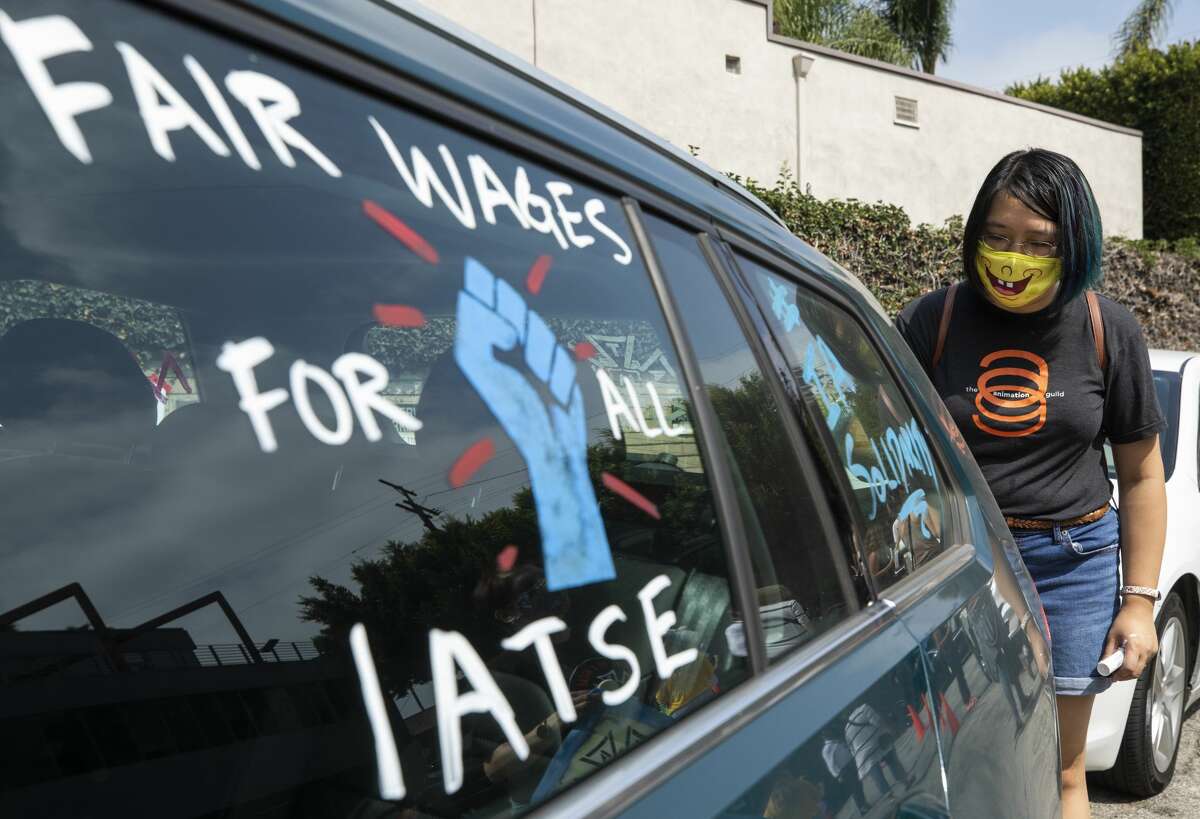 Crystal Kan, a storyboard artist, draws pro-labor signs on cars of union members during a rally at the Motion Picture Editors Guild IATSE Local 700 on Sunday, Sept. 26, 2021 in Los Angeles. Up to 60,000 members of the International Alliance of Theatrical Stage Employees (IATSE) could go on strike as early as Friday, Oct. 1. In the Hudson Valley, production of a new HBO Max series and other TV and film shoots here could be halted if union members authorize a walkout.