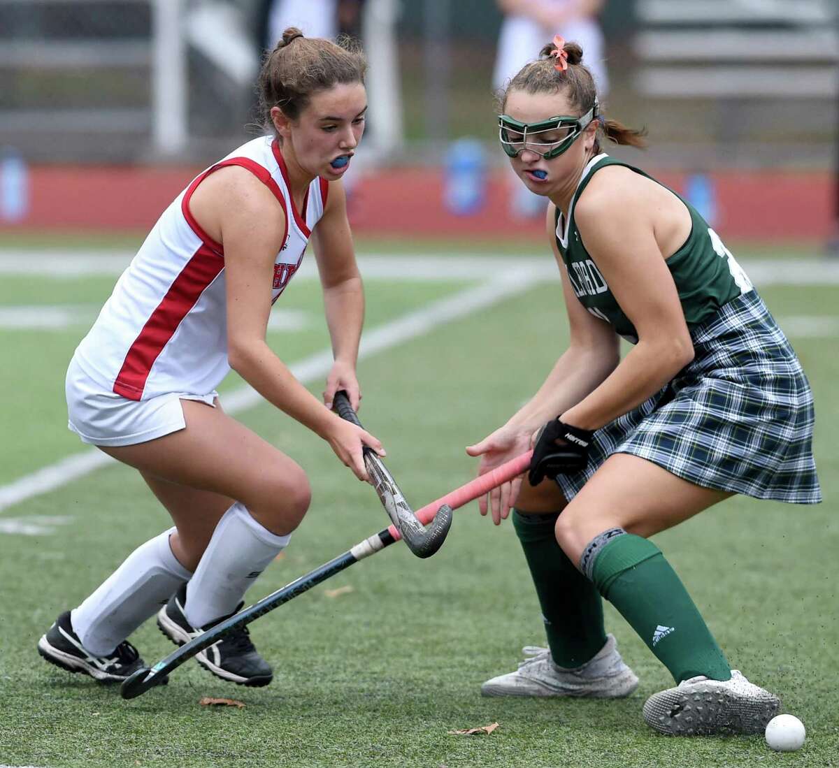 Leah Black of Cheshire (left) and Maddie Epke of Guilford fight for the ball in the SCC Division A field hockey championship at Cheshire High School on November 11, 2020.