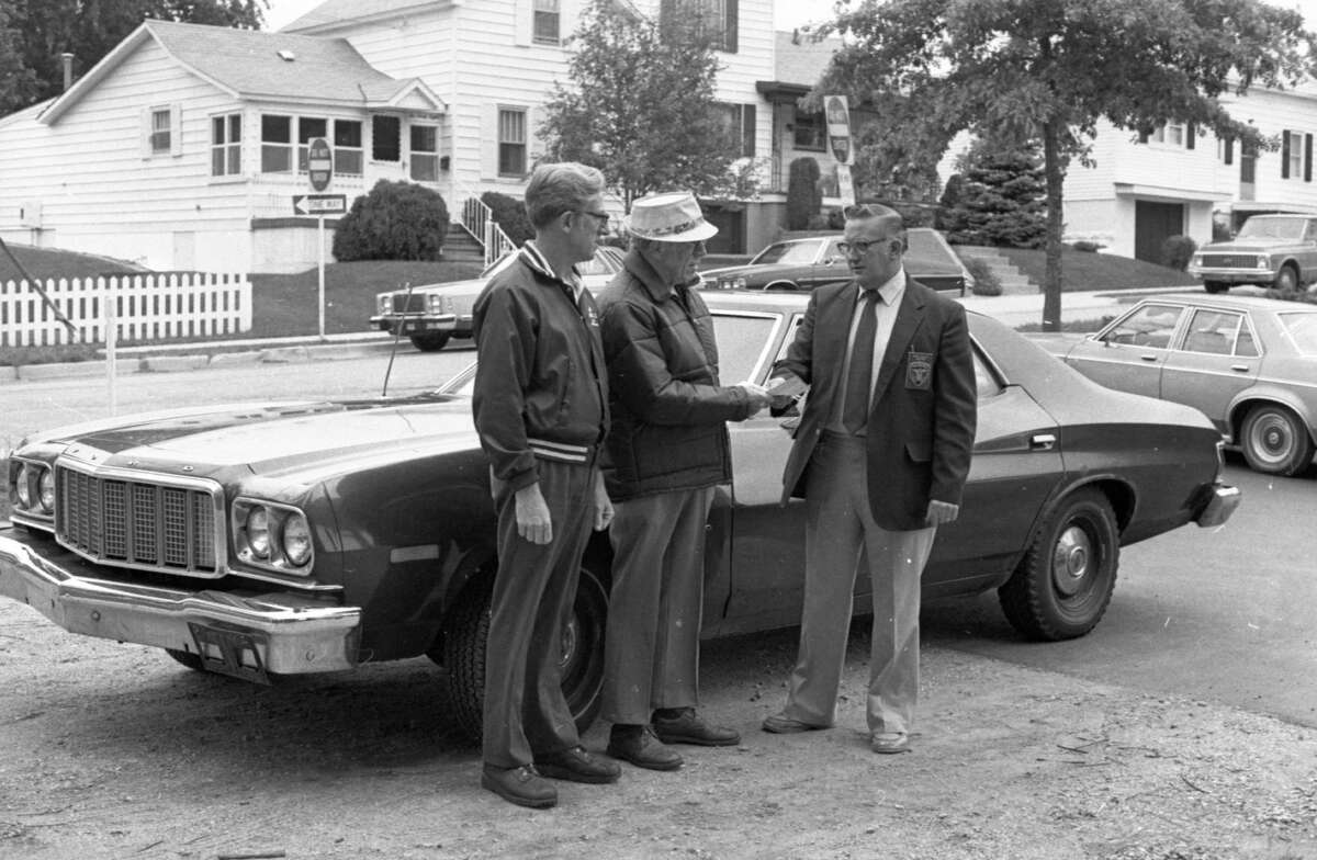 A former Manistee City Police Department car will be put to use by the city's housing commission for the mobile meals program, a food service for older adults which brings hot meals to the homes of eligible residents. (From left) Howard Fenton and Harold Marsh of the housing commission accept the keys from Public Safety Director John Willet, whose department donated the vehicle for the mobile meals program. The photo was published in the News Advocate on Sept. 30, 1981. (Manistee County Historical Museum photo)