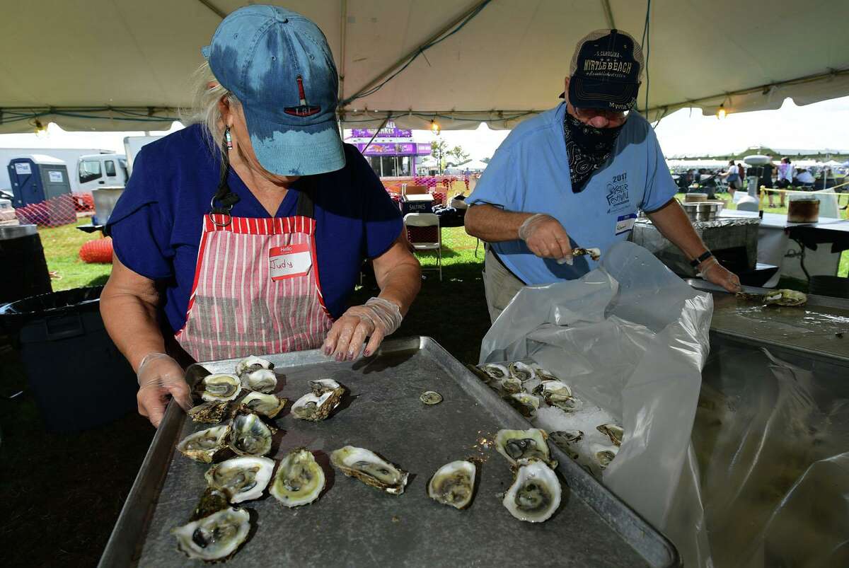 Judy Cassara and Robert Lasher ready oysters frommthe Coast Guard Auxiliary booth at the 43rd Annual Norwalk Oyster Festival Saturday, September 11, 2021, at Veterans Memorial Park in Norwalk, Conn.