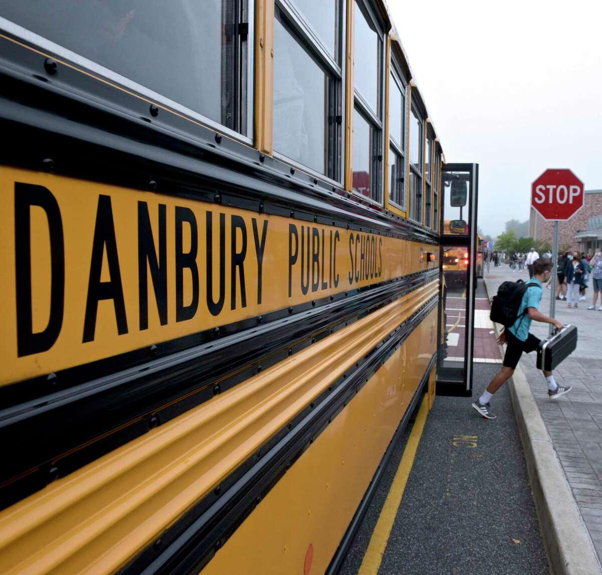 Students get of the busses at Danbury High School on the first day of the new school year on Aug. 30, 2021, in Danbury and Brookfield, Conn.