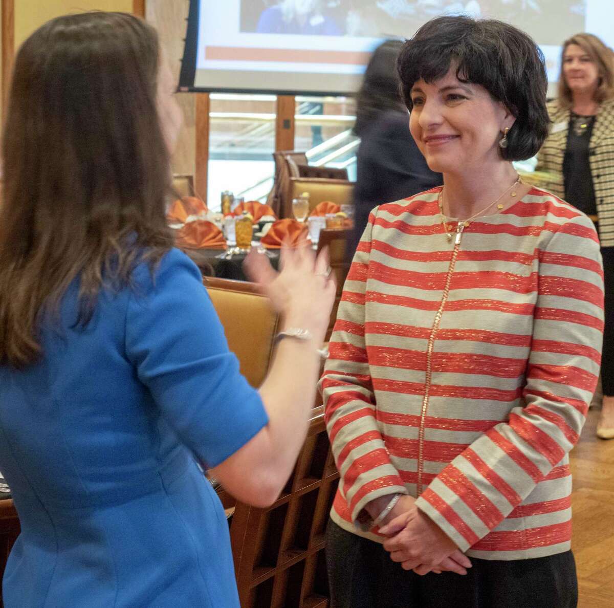 Texas Railroad Commissioner Christi Craddick, talks with Kristin Schmidt before speaking at the Women's Energy Network luncheon.