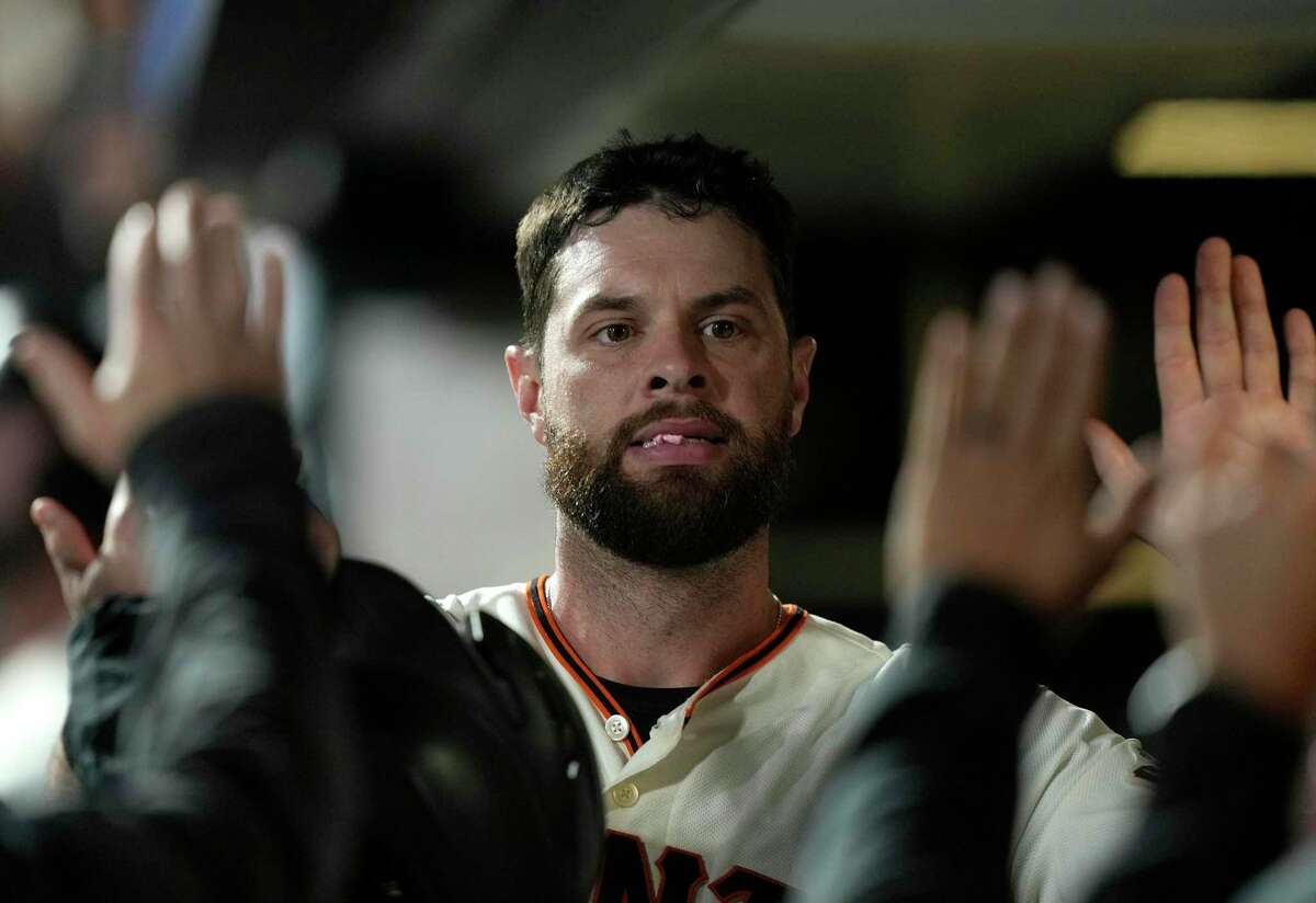 SAN FRANCISCO, CALIFORNIA - AUGUST 30: Brandon Belt #9 of the San Francisco Giants is congratulated by teammates after scoring against the Milwaukee Brewers in the bottom of the seventh inning at Oracle Park on August 30, 2021 in San Francisco, California. (Photo by Thearon W. Henderson/Getty Images)